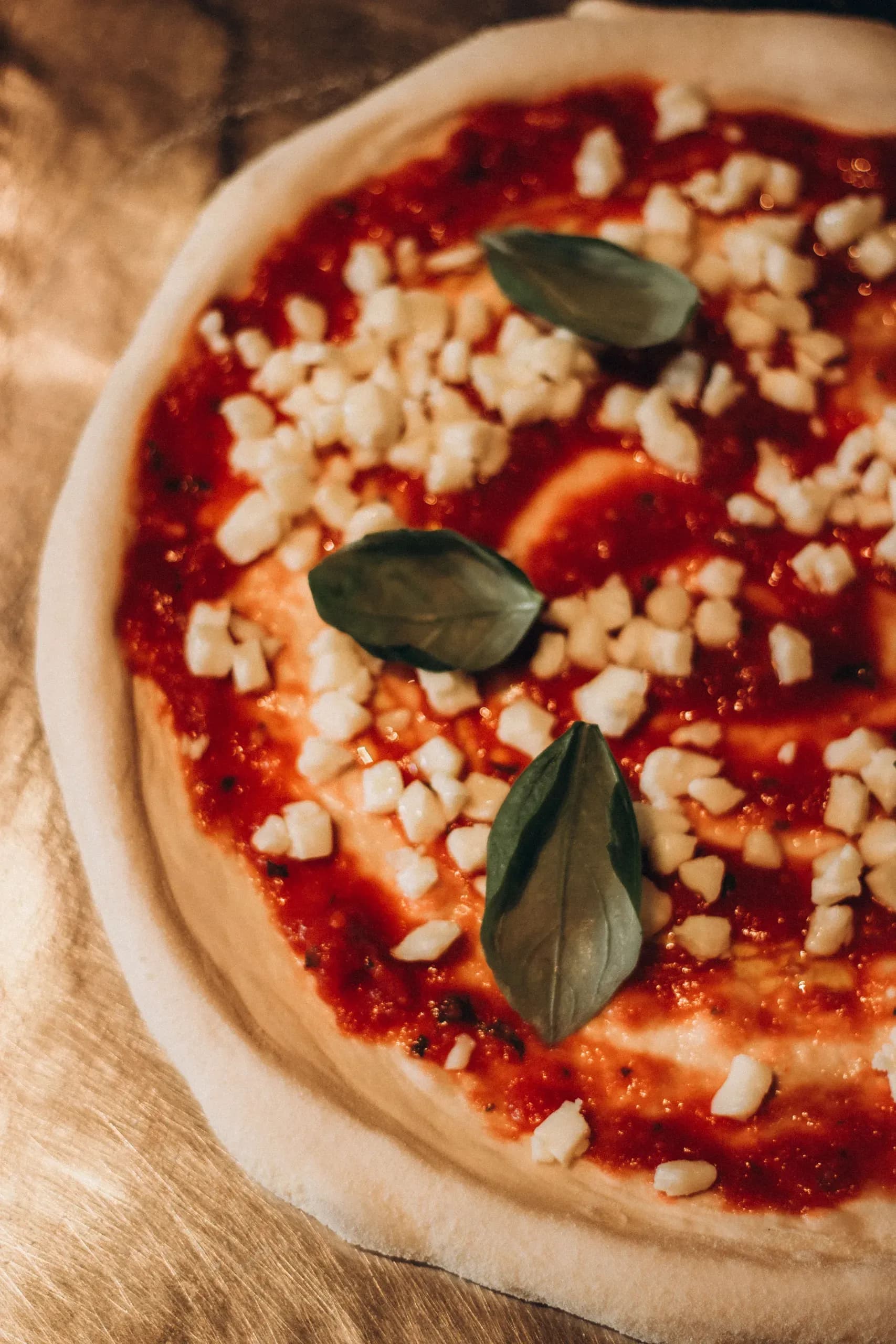 Margherita pizza with fresh mozzarella, basil, and tomato sauce on wooden surface